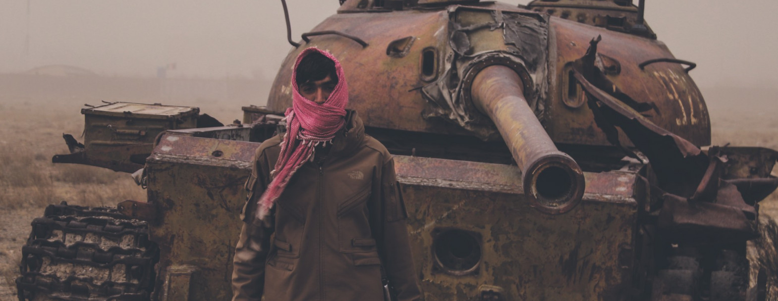 Août 2021, dans un faubourg de Kaboul (Afghanistan), un homme armé pose devant une épave de tank taliban. Août 2021, dans un faubourg de Kaboul (Afghanistan), un homme armé pose devant une épave de tank taliban. / ©iStock/Trent Inness
