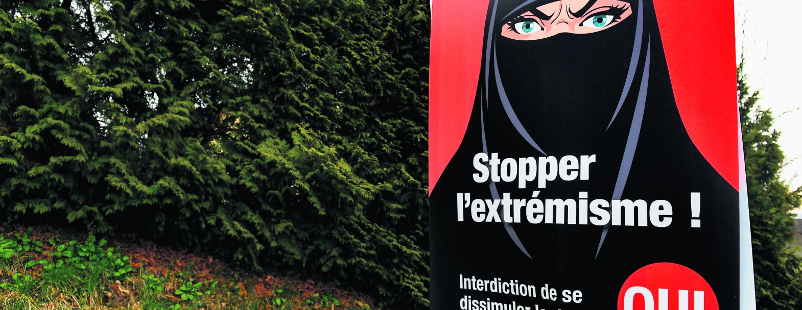 Vevey, le 7 mars 2021. Une affiche en faveur de l’interdiction de se dissimuler le visage acceptée par les électeurs suisses ce jour-là. Si le type de vêtements représentés est ultraminoritaire en Suisse, les promoteurs de l’initiative ont largement utilisé cette symbolique dans leur campagne. Vevey, le 7 mars 2021. Une affiche en faveur de l’interdiction de se dissimuler le visage acceptée par les électeurs suisses ce jour-là. Si le type de vêtements représentés est ultraminoritaire en Suisse, les promoteurs de l’initiative ont largement utilisé cette symbolique dans leur campagne. / © Shutterstock